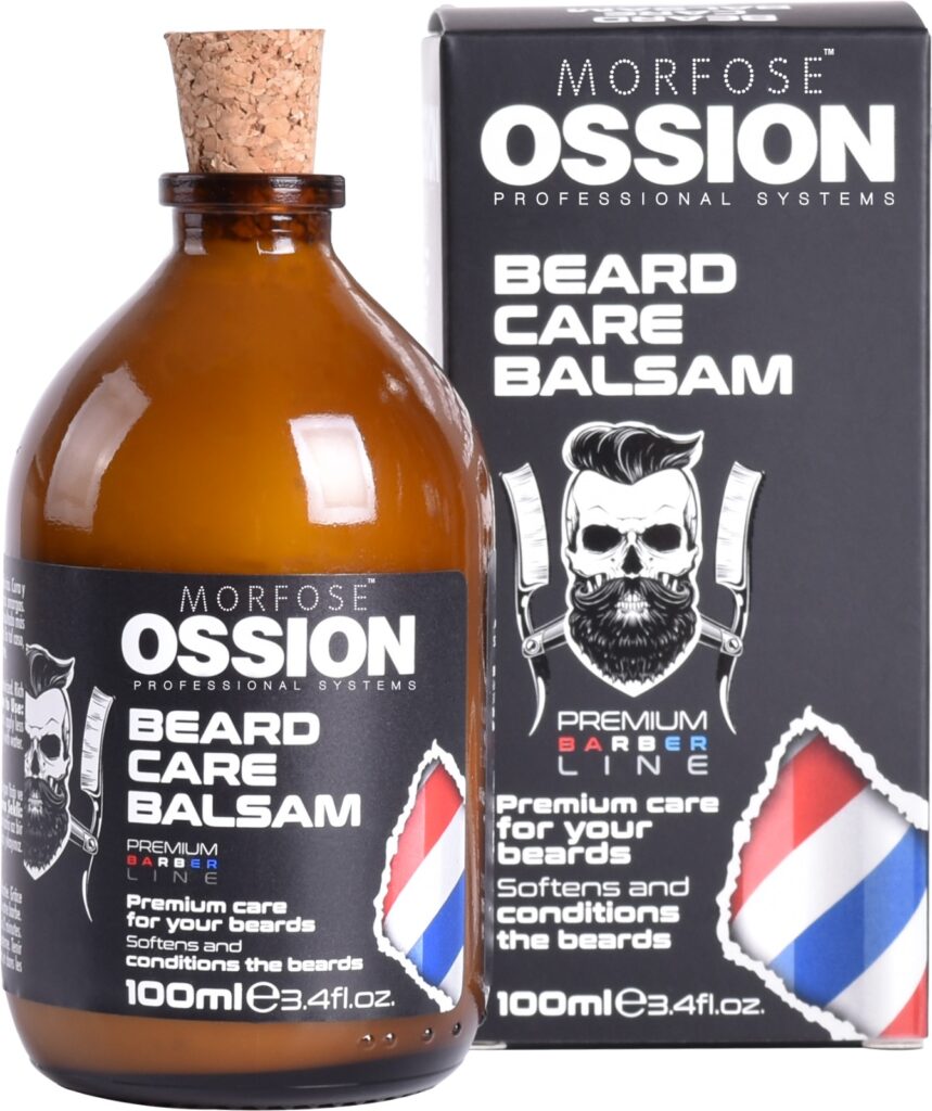 En 100 ml flaska Ossion Beard Care Balsam med ett korklock står bredvid lådan. Förpackningen innehåller en skäggig man med sax och en kam, vilket framhäver den som en premium hårprodukt för man, designad för att mjuka upp och konditionera skägg.